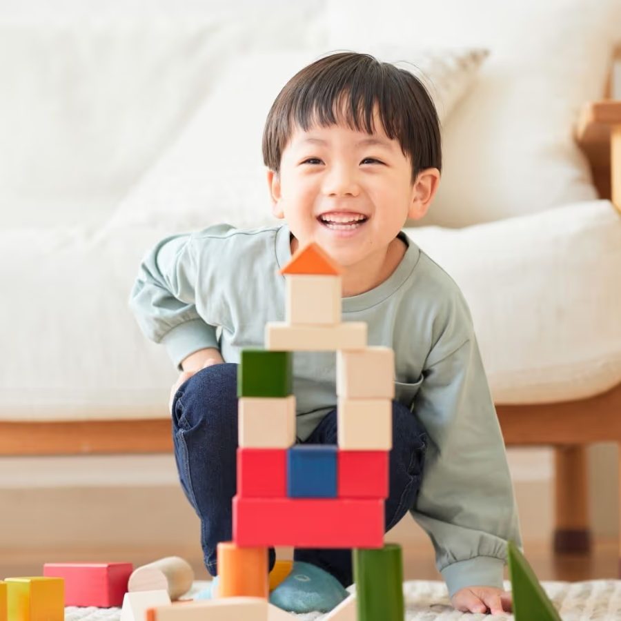 Menino sorridente brincando com blocos de montar